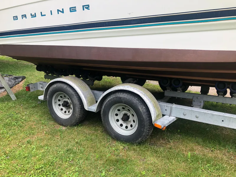 Slide: The Image of 1997 Bayliner Ciera 2452 Express on trailer, side view, parked on grass. - 3
