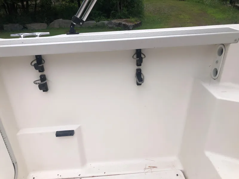 Slide: The Image of 1997 Bayliner Ciera 2452 Express boat interior with rod holders and clean white deck. - 30