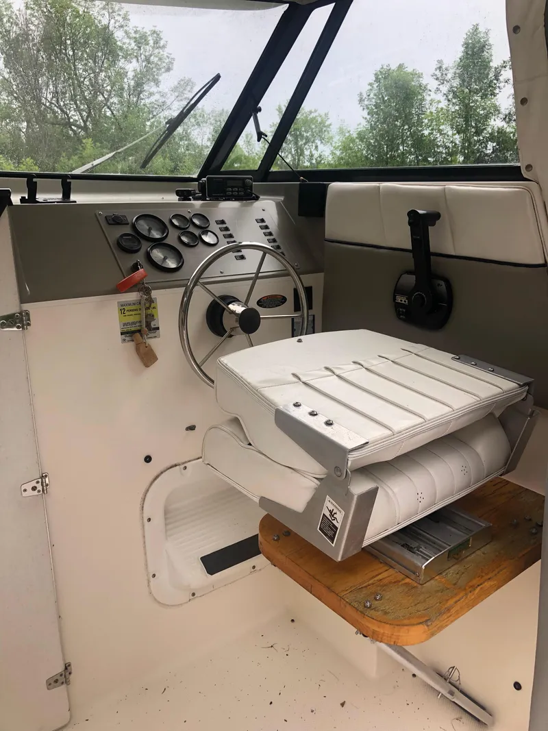 Slide: The Image of 1997 Bayliner Ciera 2452 Express helm with steering wheel and control panel. - 37