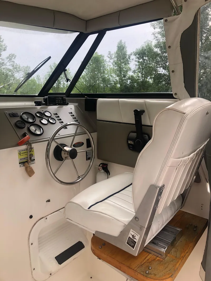 Slide: The Image of 1997 Bayliner Ciera 2452 Express helm with steering wheel and control panel. - 38