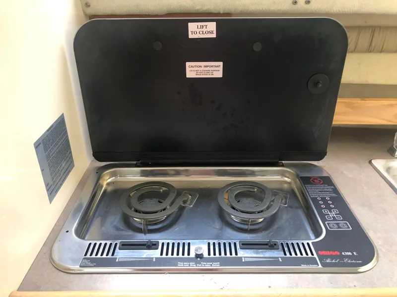 Slide: The Image of 1997 Bayliner Ciera 2452 Express stove with two burners and cover open. - 49