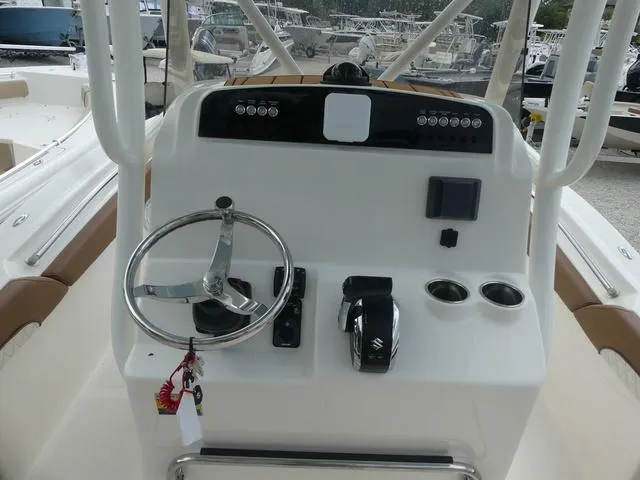 Slide: The Image of Control console of a 2025 Pioneer Islander 222 boat with steering wheel and navigation controls. - 14