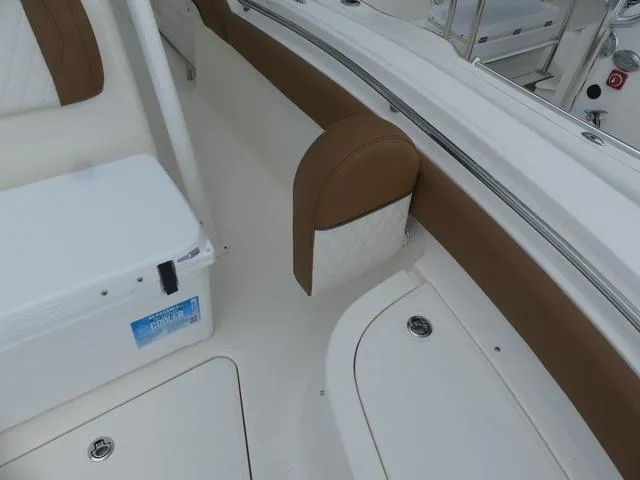 Slide: The Image of 2025 Pioneer Islander 222 boat interior with cushioned seating and white cooler. - 21