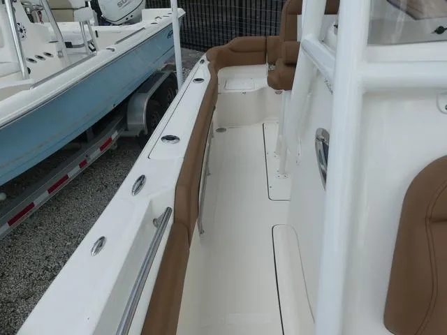 Slide: The Image of 2025 Pioneer Islander 222 boat interior with tan seating and white deck. - 24