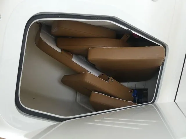 Slide: The Image of Storage compartment with brown cushions in a 2025 Pioneer Islander 222 boat. - 27