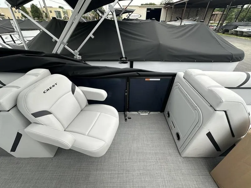 Slide: The Image of 2024 Crest Classic LX 220 SLC boat interior with white seating and covered exterior. - 10