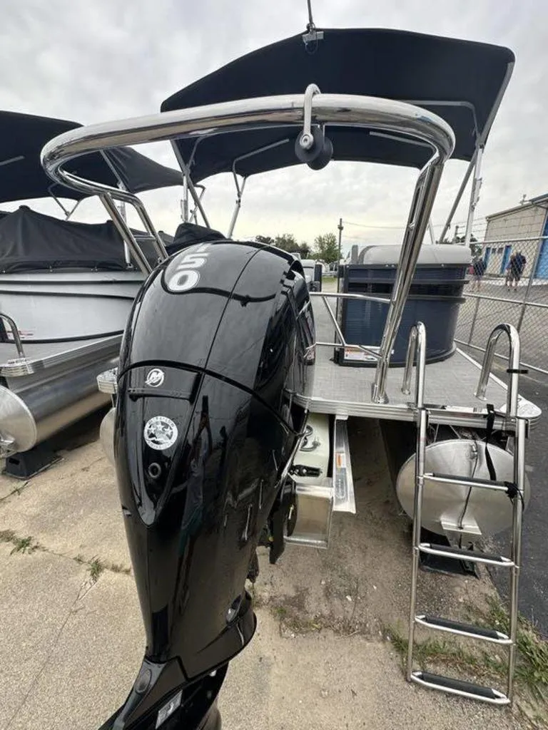 Slide: The Image of 2024 Crest Classic LX 220 SLC pontoon boat with a powerful outboard motor. - 14