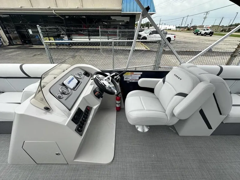 Slide: The Image of 2024 Crest Classic LX 220 SLC boat interior with captain's chair and control console. - 7
