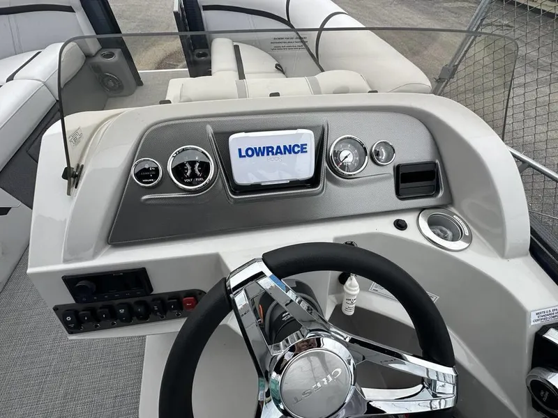 Slide: The Image of 2024 Crest Classic LX 220 SLC boat dashboard with Lowrance display and chrome steering wheel. - 8