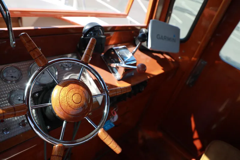 Slide: The Image of 1982 Shamrock Pilothouse boat helm with wooden steering wheel and Garmin navigation system. - 11