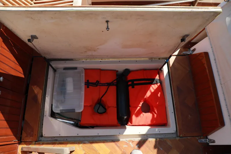 Slide: The Image of Storage compartment of a 1982 Shamrock Pilothouse boat with life jackets and gear. - 15