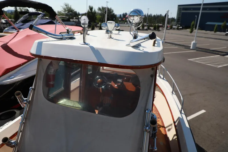 Slide: The Image of 1982 Shamrock Pilothouse boat with visible helm and deck details in a marina. - 16
