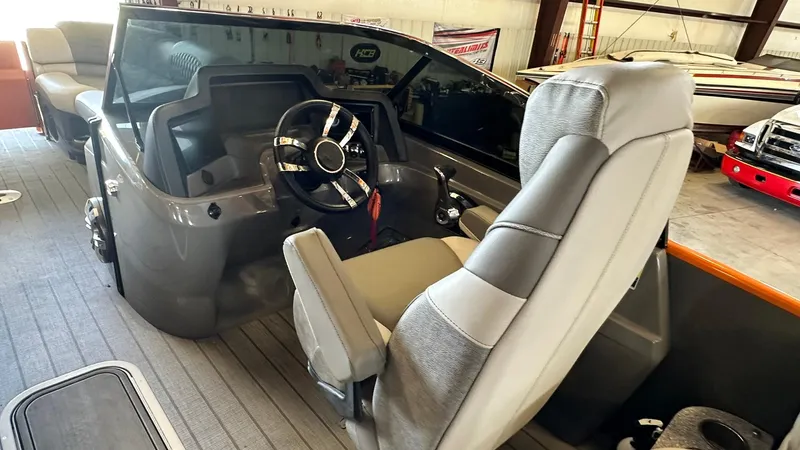 Slide: The Image of 2023 Avalon Excalibur Elite Windshield boat interior with captain's chair and steering console. - 11
