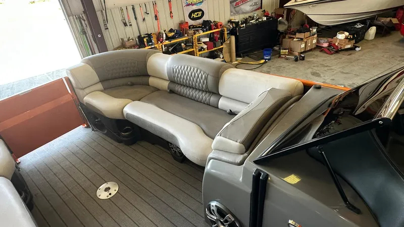 Slide: The Image of 2023 Avalon Excalibur Elite Windshield boat interior with luxurious seating in a workshop. - 13