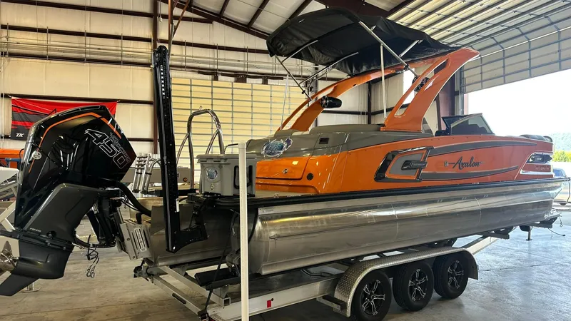 Slide: The Image of 2023 Avalon Excalibur Elite Windshield boat on trailer in warehouse. - 3