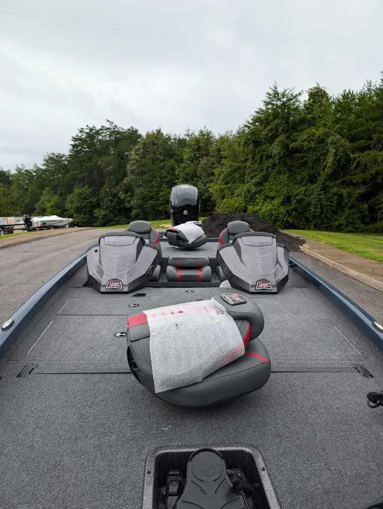 Slide: The Image of 2024 Ranger RT198P fishing boat with seating, on a road near lush greenery. - 2