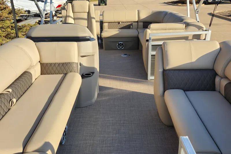 Slide: The Image of 2024 Sun Tracker Party Barge 20 DLX interior with beige seating and spacious layout. - 3
