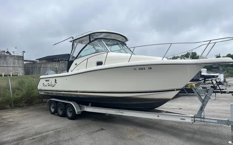 The Image of 2007 Pursuit 285 Offshore boat on a trailer in a parking lot. - 0