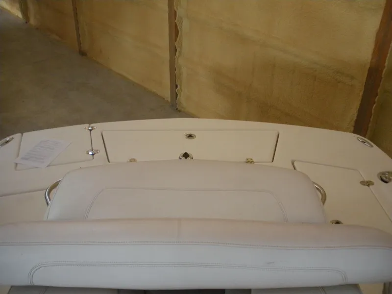 Slide: The Image of 2009 Larson LXi 258 boat interior with white seating and storage compartments. - 13