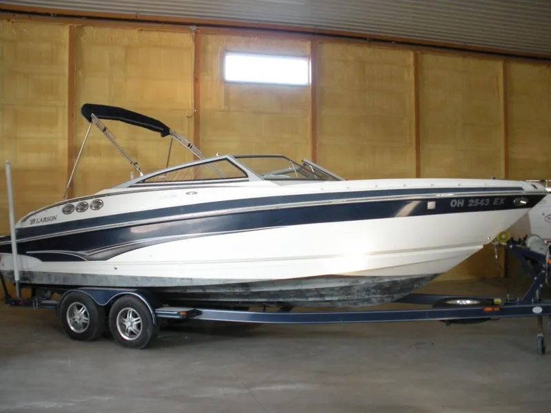 Slide: The Image of 2009 Larson LXi 258 boat on trailer in indoor storage. - 2
