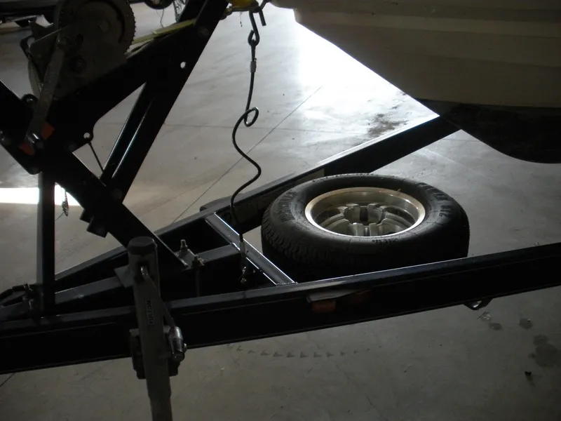 Slide: The Image of 2009 Larson LXi 258 boat trailer with spare tire in garage. - 3