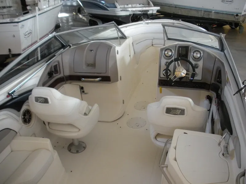 Slide: The Image of 2009 Larson LXi 258 boat interior with white seating and steering console. - 5