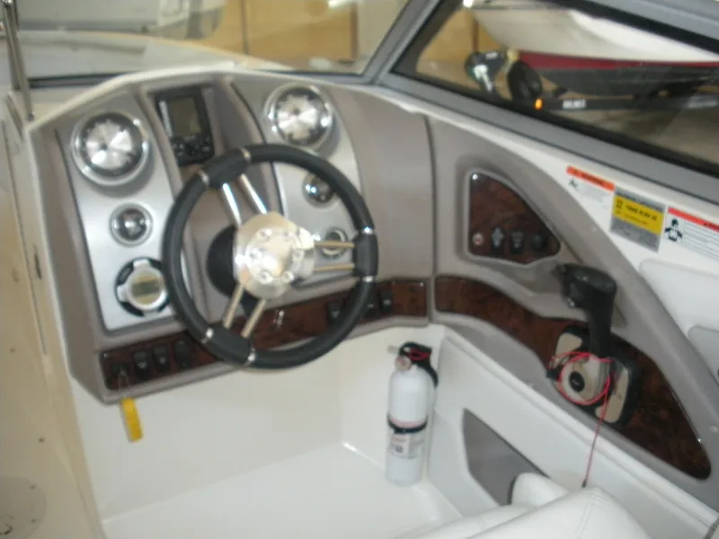 Slide: The Image of 2009 Larson LXi 258 boat cockpit with steering wheel and control panel. - 8