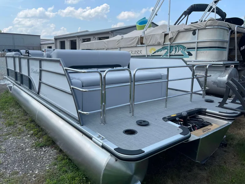 Slide: The Image of 2025 Bentley Pontoons Legacy 220 Swingback pontoon boat docked on grass. - 4
