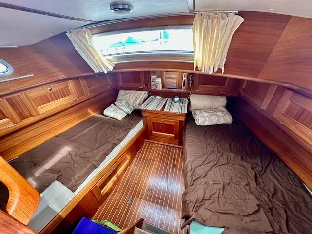 Slide: The Image of Cozy Vilm 116 yacht cabin interior with wooden finish, twin beds, and natural light. - 14
