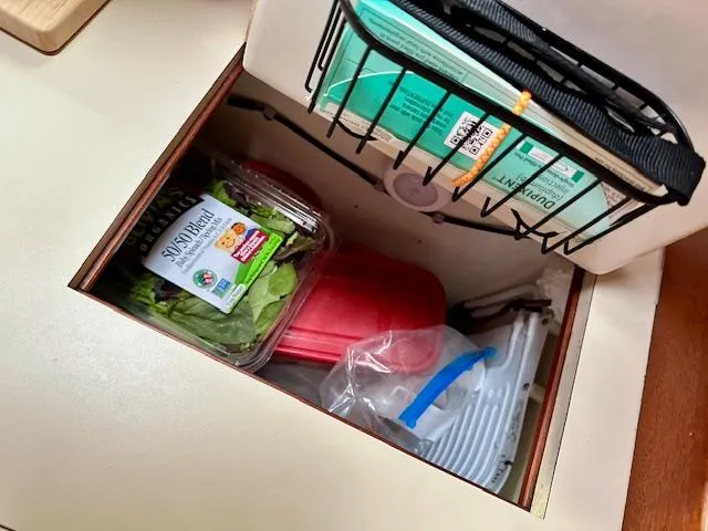 Slide: The Image of Storage compartment in Vilm 116 yacht with spinach, containers, and supplies. - 16