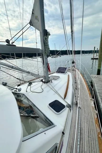 Slide: The Image of Sailboat Vilm 116, 2002 model, docked at marina with cloudy sky. - 3