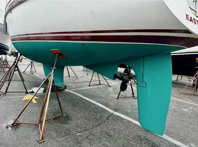 Slide: The Image of Sailboat Vilm 116 (2002) on stands, showcasing turquoise hull and rudder. - 44