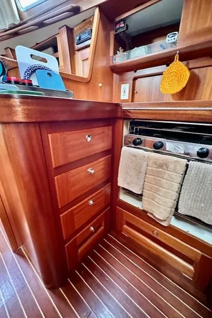 Slide: The Image of Wooden yacht kitchen interior with stove, drawers, and hanging towel. Vilm 116, 2002 model. - 9