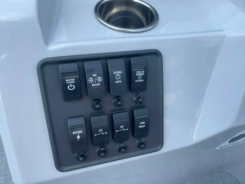 Slide: The Image of Control panel of 2025 Bentley Pontoons Bolt with various switches and cup holder. - 12