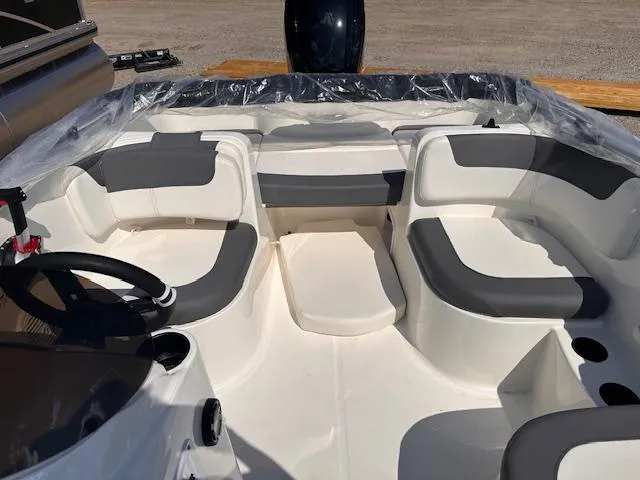 Slide: The Image of 2024 Bayliner E16LE boat interior with seating and steering wheel. - 2