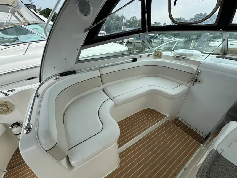 Slide: The Image of 2006 Rinker 320 Express Cruiser interior with white seating and wood flooring. - 11