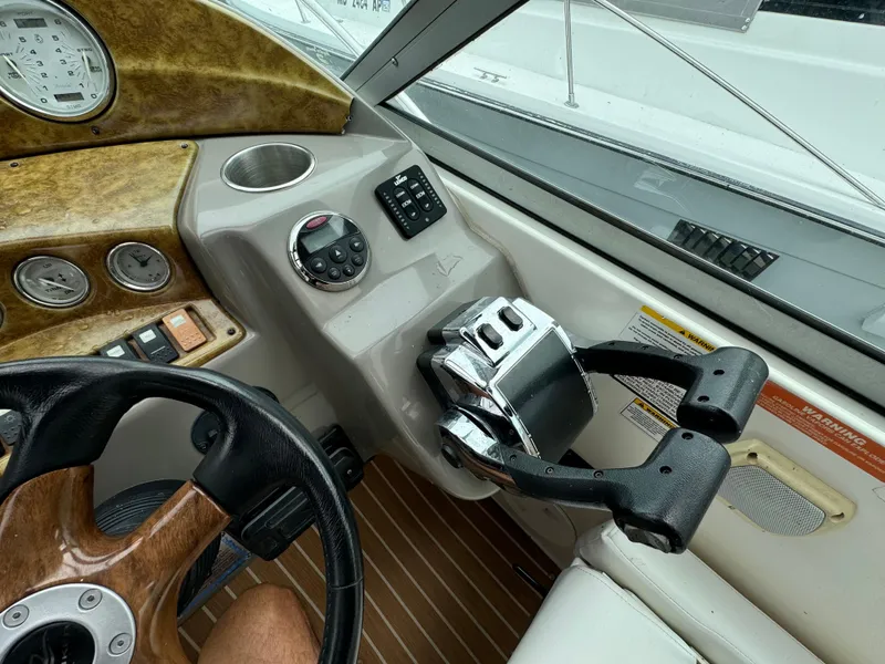 Slide: The Image of 2006 Rinker 320 Express Cruiser helm with steering wheel and control panel. - 14
