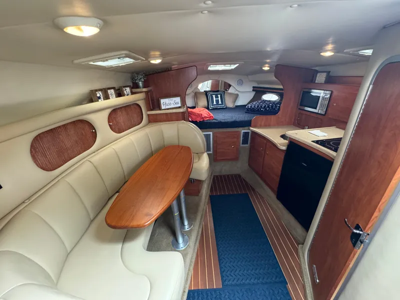 Slide: The Image of 2006 Rinker 320 Express Cruiser interior with dining area, kitchenette, and sleeping quarters. - 15