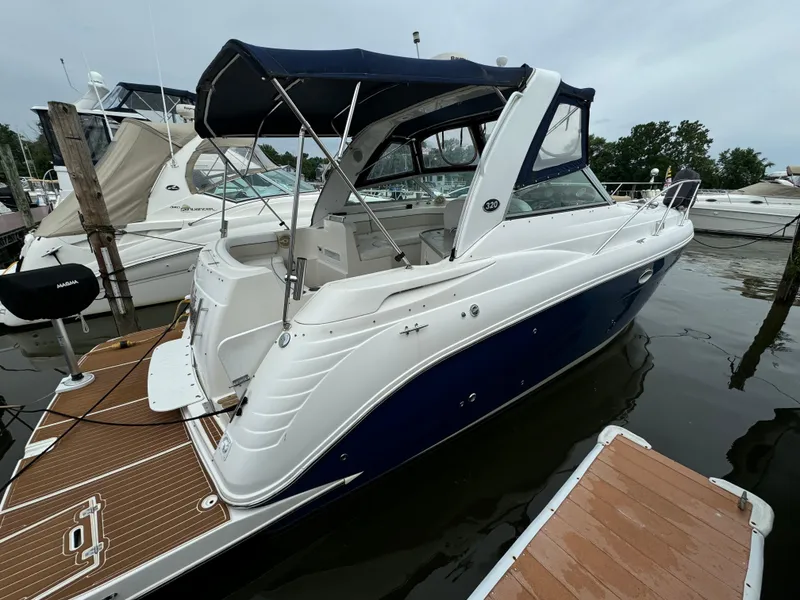 Slide: The Image of 2006 Rinker 320 Express Cruiser docked at a marina. - 2