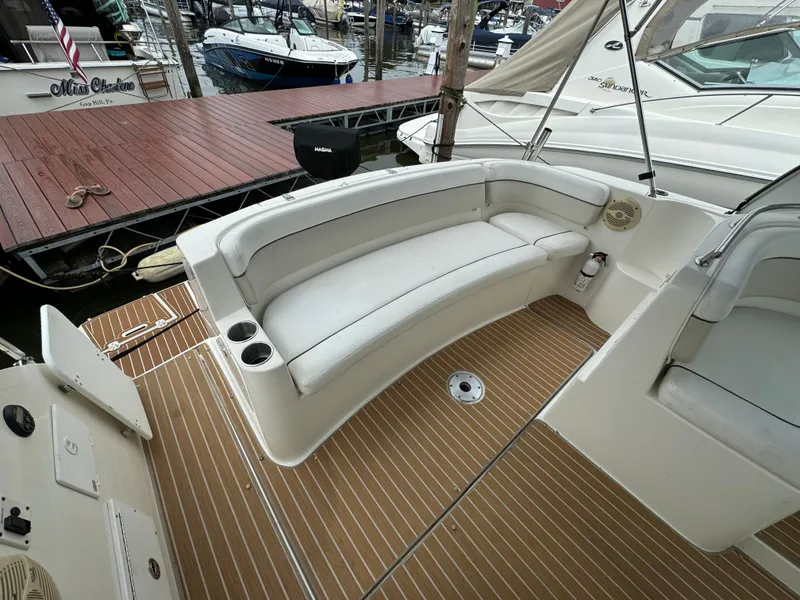 Slide: The Image of 2006 Rinker 320 Express Cruiser with white seating and teak flooring at a marina. - 9