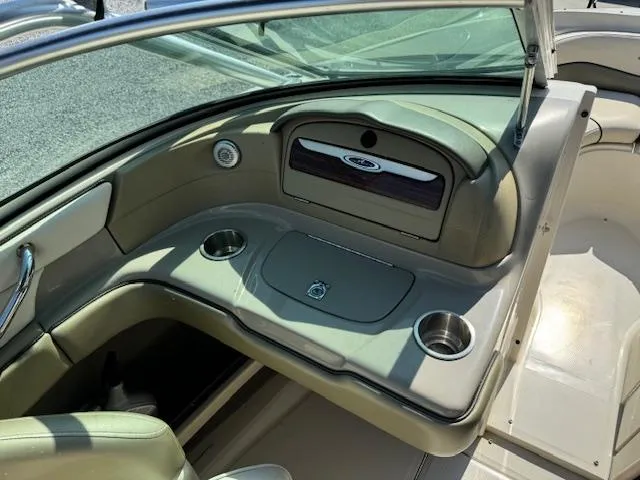 Slide: The Image of 2005 Sea Ray 200 Select boat interior with cup holders and storage compartment. - 13