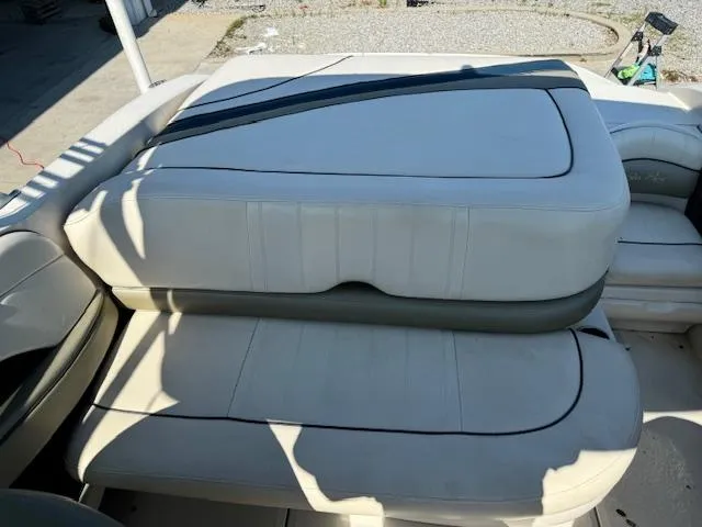 Slide: The Image of 2005 Sea Ray 200 Select boat interior seating with white upholstery. - 14