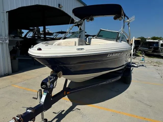 Slide: The Image of 2005 Sea Ray 200 Select boat on trailer with bimini top, parked outside a storage facility. - 5