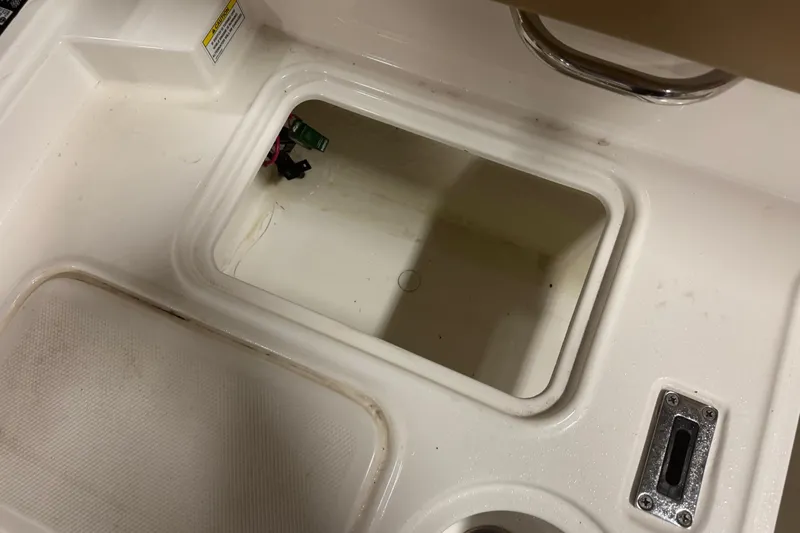 Slide: The Image of Storage compartment on a 2023 Bayliner DX 2000 boat, featuring a clean, white interior. - 14