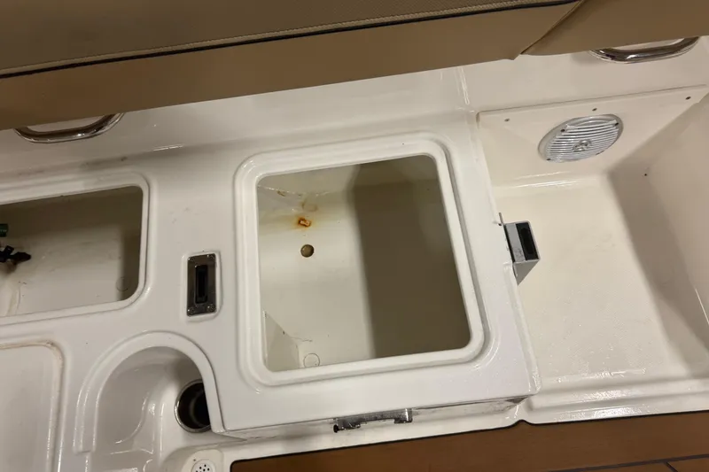 Slide: The Image of 2023 Bayliner DX 2000 boat interior storage compartments and seating area. - 15