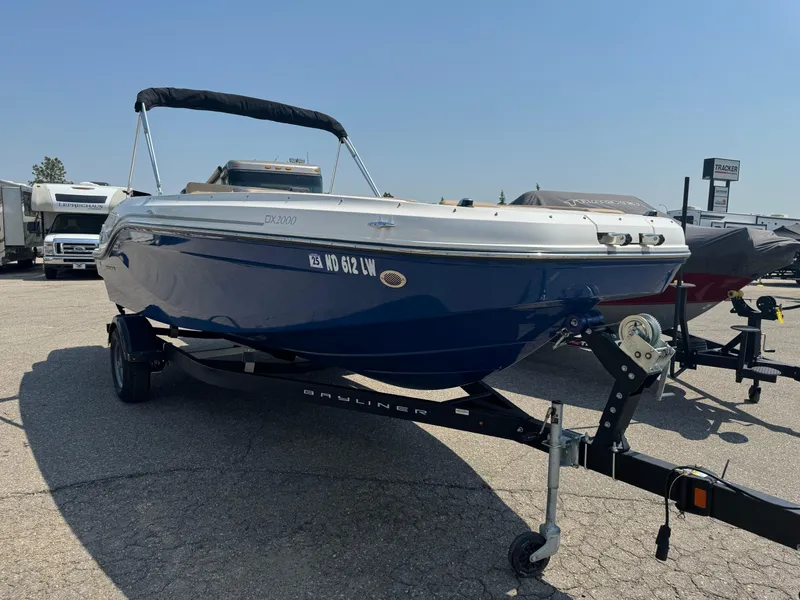 Slide: The Image of 2023 Bayliner DX 2000 boat on trailer in indoor storage facility. - 2