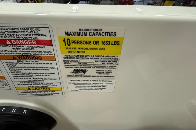 Slide: The Image of 2023 Bayliner DX 2000 capacity label, 10 persons or 1653 lbs, safety warnings visible. - 27