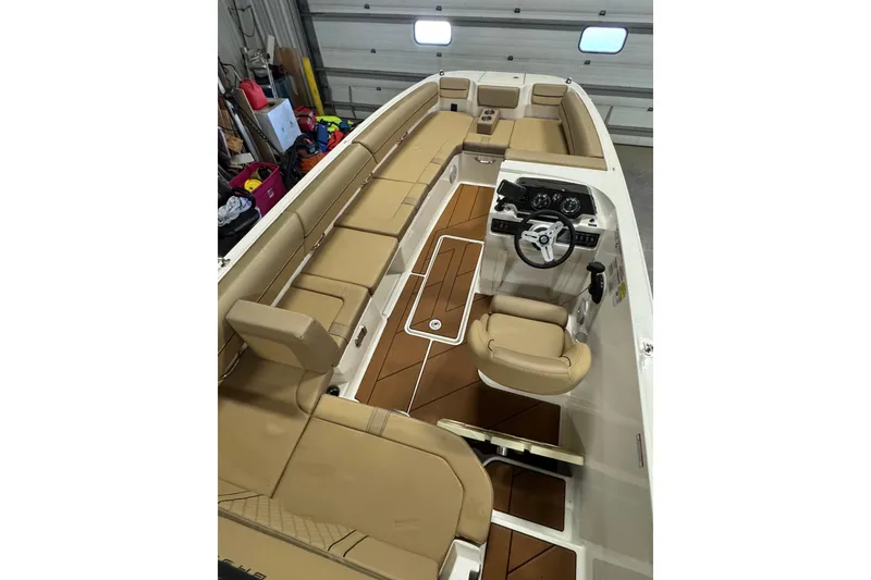 Slide: The Image of 2023 Bayliner DX 2000 boat interior with tan seating and modern dashboard. - 28