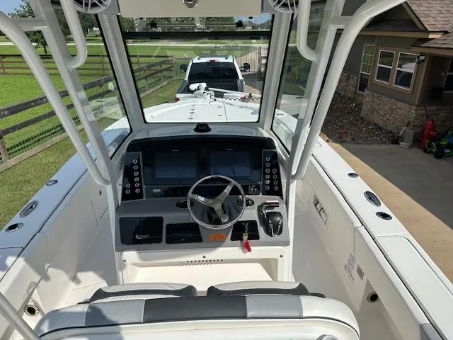 Slide: The Image of 2022 Robalo 266 Cayman boat cockpit with dual screens and steering wheel. - 11