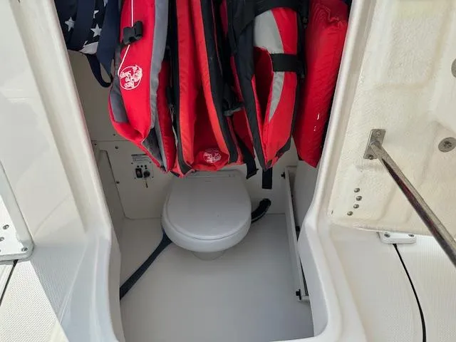 Slide: The Image of 2022 Robalo 266 Cayman boat interior with life jackets and toilet. - 13